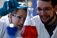 Two researchers looking at chemical in the lab
